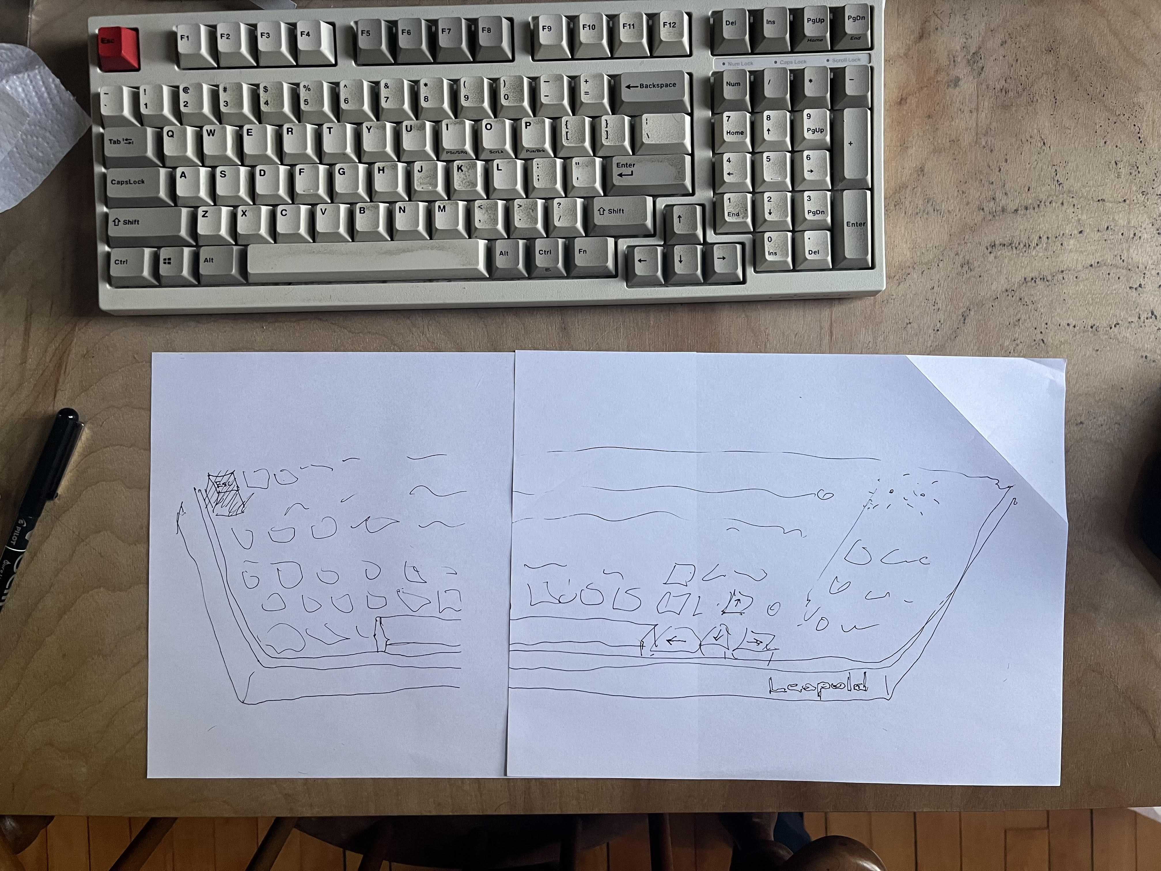 Keyboard viewed from above with the keyboard exercise scrawled on a piece of paper below it on a desk